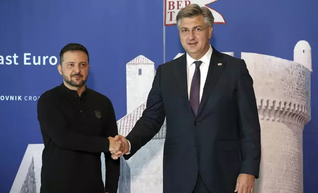 Ukrainian President Volodymyr Zelenskyy, left, is welcomed by Croatian Prime Minister Andrej Plenkovic at the Southeast Europe Croatia Ukraine summit in Dubrovnik, Croatia, Wednesday, Oct. 9, 2024. (Damir Sencar/Pool Photo via AP)