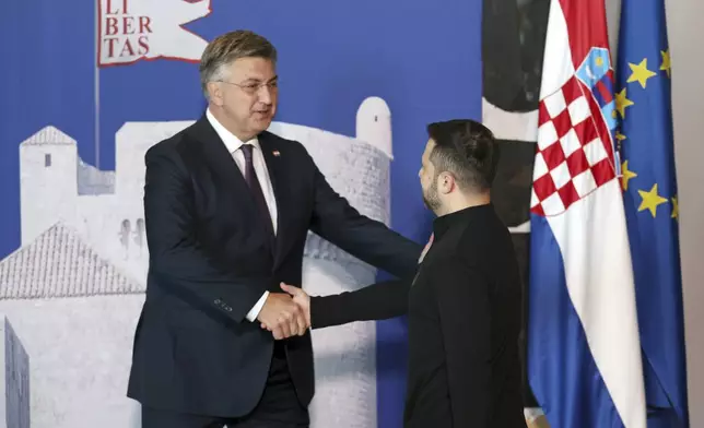 Ukrainian President Volodymyr Zelenskyy, right, is welcomed by Croatian Prime Minister Andrej Plenkovic at the Southeast Europe Croatia Ukraine summit in Dubrovnik, Croatia, Wednesday, Oct. 9, 2024. (Damir Sencar/Pool Photo via AP)