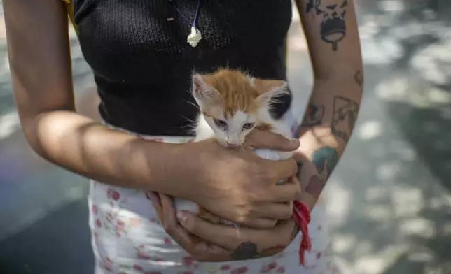 A girl holds her newly adopted kitten at an animal adoption fair in Havana, Cuba, Saturday, Sept. 28, 2024. (AP Photo/Ramon Espinosa)