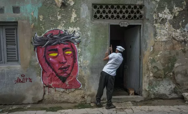 A cook looks in on a resident during a massive blackout after a major power plant failed in Havana, Cuba, Saturday, Oct. 19, 2024. (AP Photo/Ramon Espinosa)