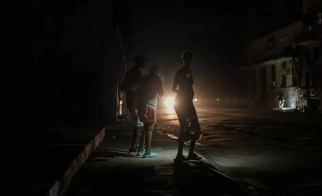 Residents walk on a street during a blackout following the failure of a major power plant in Havana, Cuba, Sunday, Oct. 20, 2024. (AP Photo/Ramon Espinosa)