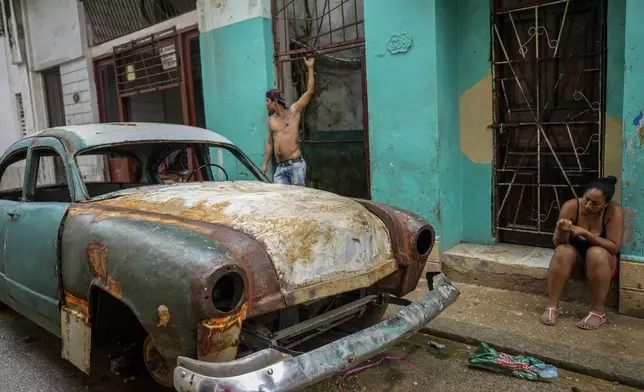 Residents stand outside their homes to avoid the heat indoors during a massive blackout after a major power plant failed in Havana, Cuba, Saturday, Oct. 19, 2024. (AP Photo/Ramon Espinosa)