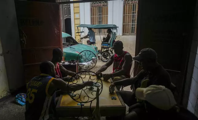 Residents play dominoes during a massive blackout after a major power plant failed in Havana, Cuba, Saturday, Oct. 19, 2024. (AP Photo/Ramon Espinosa)