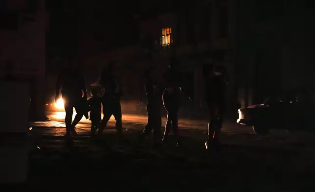 Residents walk on a street during a blackout following the failure of a major power plant in Havana, Cuba, Sunday, Oct. 20, 2024. (AP Photo/Ramon Espinosa)