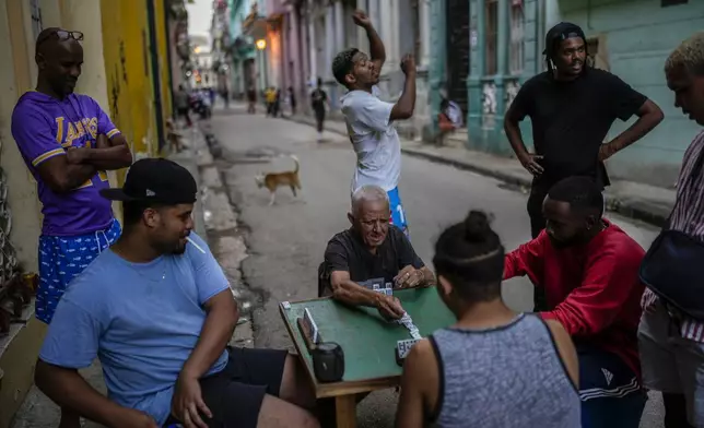 People play dominoes on the street during a power outage in Havana, Cuba, Monday, Oct. 21, 2024. (AP Photo/Ramon Espinosa)
