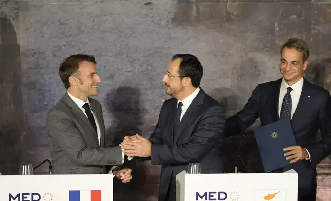 French President Emmanuel Macron, left, shakes hands with Cyprus' President Nikos Christodoulides, as Greece's Prime Minister Kyriakos Mitsitakis approach them after the end of a press conference in Paphos ,Cyprus, on Friday, Oct 11, 2024 as the leaders of nine southern European Union member countries and Jordan are meeting to come up with ways of de-escalating the conflict in the Middle East (AP Photo/Petros Karadjias)