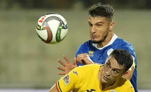 Cyprus' Kostakis Artymatas, rear, and Romania's Nicolae Stanciu fight for the ball during the Nations League soccer match between Cyprus and the Romania at the AEK Arena in Larnaca, Cyprus, Saturday, Oct. 12, 2024. (AP Photo/Petros Karadjias)