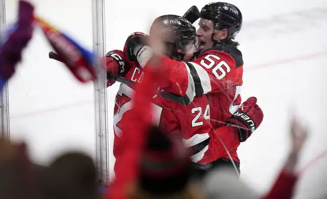 New Jersey Devils' Seamus Casey, left, celebrates with New Jersey Devils' Erik Haula after scoring his sides first goal during the NHL hockey game between Buffalo Sabres and New Jersey Devils, in Prague, Czech Republic, Saturday, Oct. 5, 2024. (AP Photo/Petr David Josek)