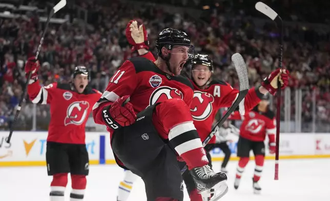 New Jersey Devils' Stefan Noesen, centre, celebrates after scoring the opening goal during the NHL hockey game between Buffalo Sabres and New Jersey Devils, in Prague, Czech Republic, Friday, Oct. 4, 2024. (AP Photo/Petr David Josek)