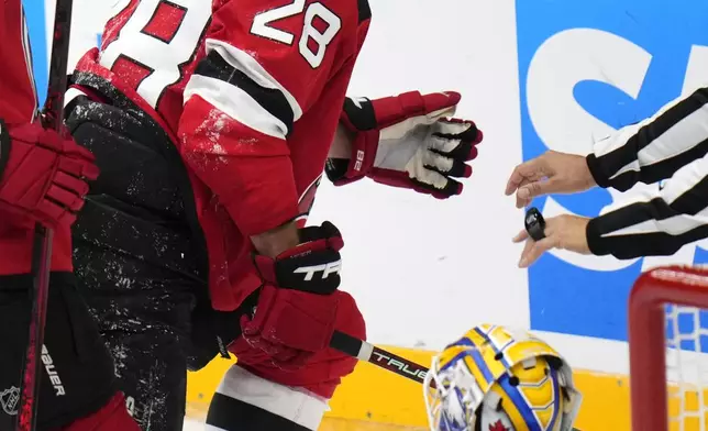 New Jersey Devils' Timo Meier, left, celebrates after scoring his sides third goal past Buffalo Sabres' Devon Levi during the NHL hockey game between Buffalo Sabres and New Jersey Devils, in Prague, Czech Republic, Saturday, Oct. 5, 2024. (AP Photo/Petr David Josek)