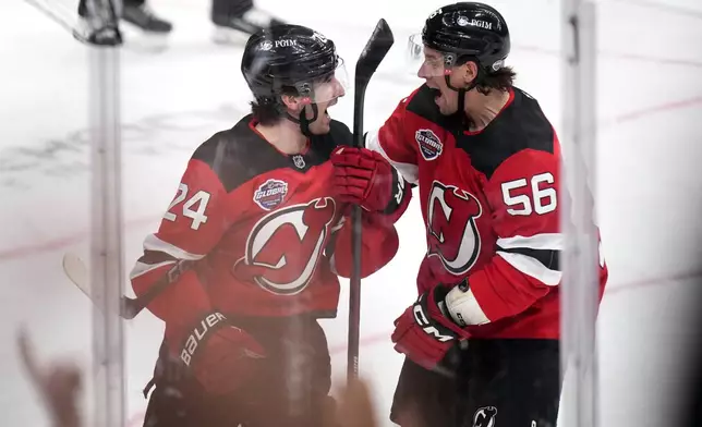 New Jersey Devils' Seamus Casey, left, celebrates with New Jersey Devils' Erik Haula after scoring his sides first goal during the NHL hockey game between Buffalo Sabres and New Jersey Devils, in Prague, Czech Republic, Saturday, Oct. 5, 2024. (AP Photo/Petr David Josek)