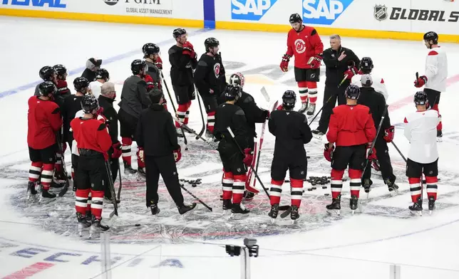 New Jersey Devils' listen to their coaches during a practice session, a day before their NHL hockey game against Buffalo Sabres, in Prague, Czech Republic, Thursday, Oct. 3, 2024. (AP Photo/Petr David Josek)