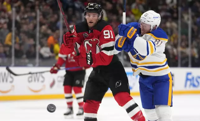 Buffalo Sabres' Ukko-Pekka Luukkonen challenges New Jersey Devils' Dawson Mercer during the NHL hockey game between Buffalo Sabres and New Jersey Devils, in Prague, Czech Republic, Saturday, Oct. 5, 2024. (AP Photo/Petr David Josek)