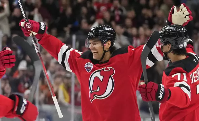 New Jersey Devils' Johnathan Kovacevic, center, celebrates after scoring his side's second goal during the NHL hockey game between Buffalo Sabres and New Jersey Devils, in Prague, Czech Republic, Friday, Oct. 4, 2024. (AP Photo/Petr David Josek)