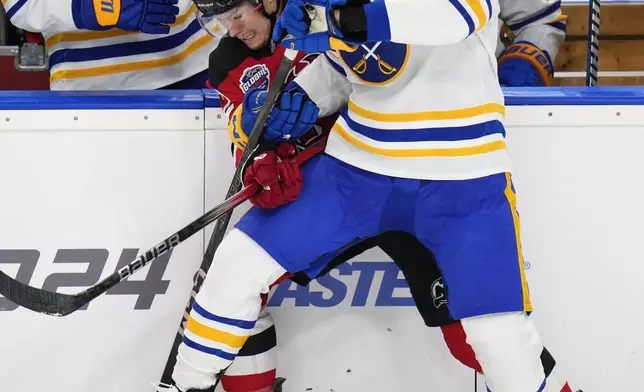 Buffalo Sabres' Alex Tuch, right, challenges New Jersey Devils' Curtis Lazar during the NHL hockey game between Buffalo Sabres and New Jersey Devils, in Prague, Czech Republic, Saturday, Oct. 5, 2024. (AP Photo/Petr David Josek)