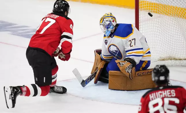 New Jersey Devils' Paul Cotter scores his sides second goal past Buffalo Sabres' Devon Levi during the NHL hockey game between Buffalo Sabres and New Jersey Devils, in Prague, Czech Republic, Saturday, Oct. 5, 2024. (AP Photo/Petr David Josek)