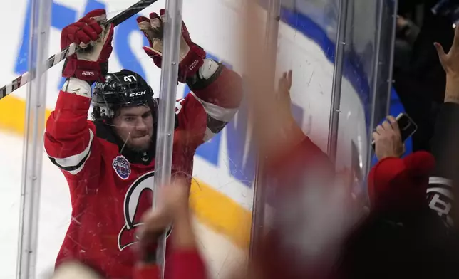 New Jersey Devils' Paul Cotter celebrates after scoring his sides second goal during the NHL hockey game between Buffalo Sabres and New Jersey Devils, in Prague, Czech Republic, Saturday, Oct. 5, 2024. (AP Photo/Petr David Josek)