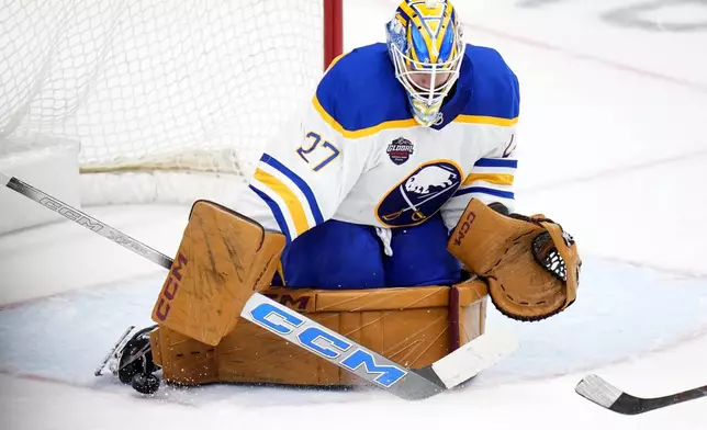 Buffalo Sabres' Devon Levi makes a save during the NHL hockey game between Buffalo Sabres and New Jersey Devils, in Prague, Czech Republic, Saturday, Oct. 5, 2024. (AP Photo/Petr David Josek)