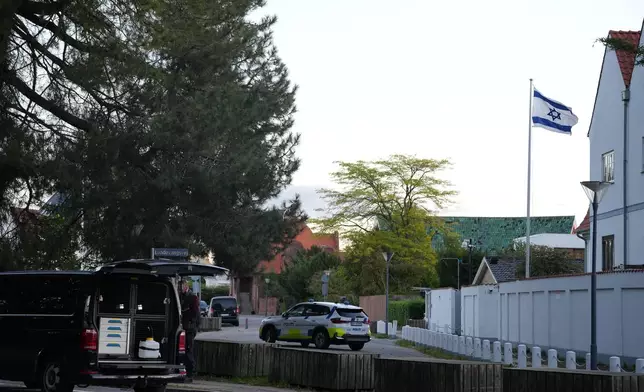 A police vehicle is seen near the Israeli embassy in Copenhagen, as police investigate two explosions near the site, on Wednesday, Oct. 2, 2024. (Emil Helms/Ritzau Scanpix via AP)