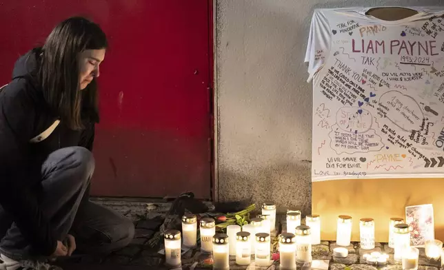 A girl reacts next to a makeshift althar for the deceased singer Liam Payne is pictured at Forum in Copenhagen, Thursday, Oct. 17, 2024. (Emil Nicolai Helms/Ritzau Scanpix via AP)