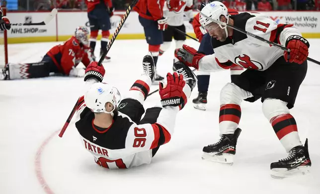 New Jersey Devils left wing Tomas Tatar (90) celebrates his goal with right wing Stefan Noesen (11) during the second period of an NHL hockey game against the Washington Capitals, Saturday, Oct. 12, 2024, in Washington. (AP Photo/Nick Wass)