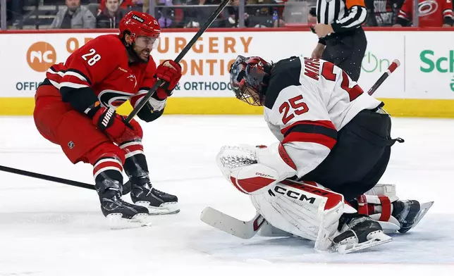 Carolina Hurricanes' William Carrier (28) has his shot swallowed by New Jersey Devils goaltender Jacob Markstrom (25) during the second period of an NHL hockey game in Raleigh, N.C., Tuesday, Oct. 15, 2024. (AP Photo/Karl B DeBlaker)