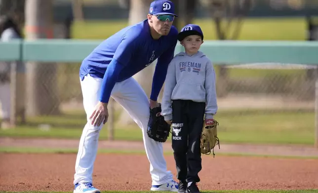 FILE - Los Angeles Dodgers first baseman Freddie Freeman, left, and his son Charlie, right, participate in spring training baseball workouts at Camelback Ranch in Phoenix, Feb. 18, 2024. (AP Photo/Ashley Landis, File)