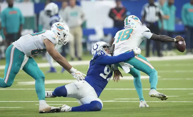 Indianapolis Colts defensive end Laiatu Latu (97) Sacks Miami Dolphins quarterback Tyler Huntley (18) as tight end Julian Hill, left, attempts to stop him during the second half of an NFL football game, Sunday, Oct. 20, 2024 in Indianapolis. (AP Photo/AJ Mast)