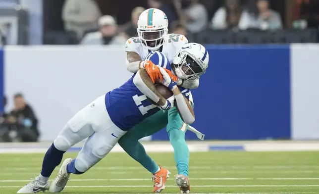 Indianapolis Colts wide receiver Michael Pittman Jr. (11) is taken down by Miami Dolphins cornerback Kendall Fuller (29) during the first half of an NFL football game, Sunday, Oct. 20, 2024 in Indianapolis. (AP Photo/AJ Mast)