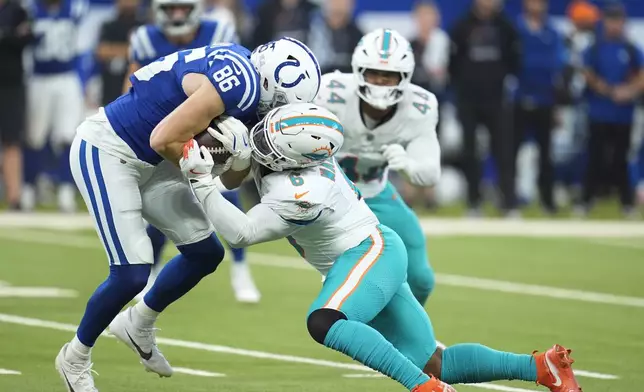 Miami Dolphins linebacker Anthony Walker Jr. (6) tackles Indianapolis Colts tight end Will Mallory (86) during the first half of an NFL football game, Sunday, Oct. 20, 2024 in Indianapolis. (AP Photo/Michael Conroy)