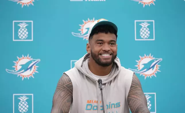 Miami Dolphins quarterback Tua Tagovailoa smiles as he takes questions during a news conference, Monday, Oct. 21, 2024, at the Dolphins training facility in Miami Gardens, Fla. (AP Photo/Wilfredo Lee)