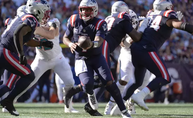 New England Patriots quarterback Jacoby Brissett, center, sets to hand off the ball against the Miami Dolphins during the second half of an NFL football game, Sunday, Oct. 6, 2024, in Foxborough, Mass. (AP Photo/Michael Dwyer)