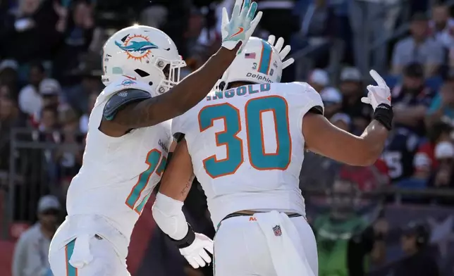 Miami Dolphins fullback Alec Ingold (30) celebrates after his touchdown during the second half of an NFL football game against the New England Patriots, Sunday, Oct. 6, 2024, in Foxborough, Mass. (AP Photo/Michael Dwyer)