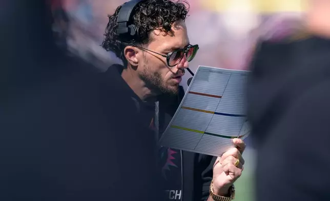 Miami Dolphins head coach Mike McDaniel took at the play sheet during the first half of an NFL football game against the New England Patriots, Sunday, Oct. 6, 2024, in Foxborough, Mass. (AP Photo/Steven Senne)