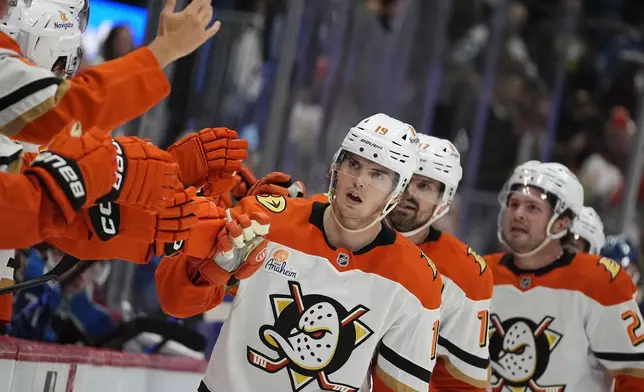 Anaheim Ducks right wing Troy Terry (19) is congratulated by teammates after scoring in the third period of an NHL hockey game against the Colorado Avalanche Friday, Oct. 18, 2024, in Denver. (AP Photo/David Zalubowski)