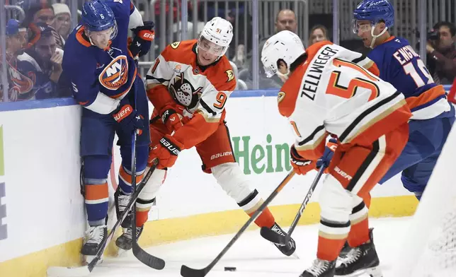 New York Islanders' Ryan Pulock and Anaheim Ducks' Leo Carlsson battle for the puck during the second period of an NHL hockey game, Tuesday, Oct. 29, 2024 in Elmont, N.Y. (AP Photo/Heather Khalifa)