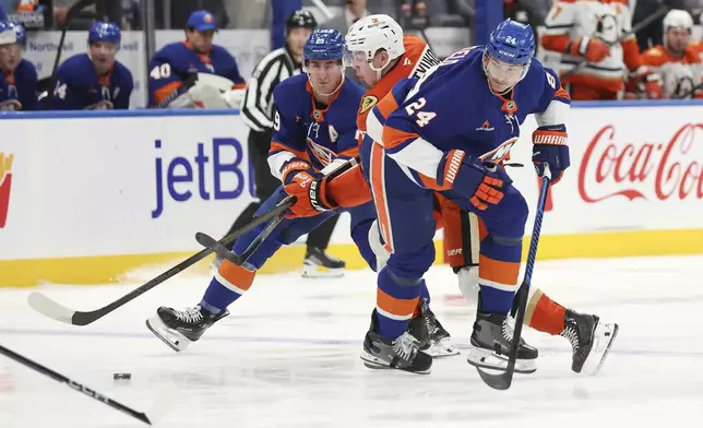 New York Islanders' Brock Nelson and Anaheim Ducks' Pavel Mintyukov battle for control of the puck while New York Islanders' Scott Mayfield looks on during the first period of an NHL game, Tuesday, Oct. 29, 2024 in Elmont, N.Y. (AP Photo/Heather Khalifa)