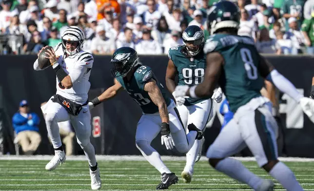 Cincinnati Bengals quarterback Joe Burrow, left, runs for yardage as Philadelphia Eagles linebacker Zack Baun (53) tries to stop him during the second half of an NFL football game, Sunday, Oct. 27, 2024 in Cincinnati. (AP Photo/Jeff Dean)