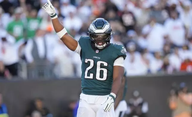 Philadelphia Eagles running back Saquon Barkley (26) reacts after teammate Jalen Hurts (1) scored a touchdown against the Cincinnati Bengals during the second half of an NFL football game, Sunday, Oct. 27, 2024 in Cincinnati. The Eagles won 37-17. (AP Photo/Carolyn Kaster)