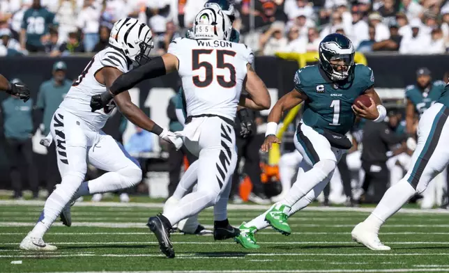 Philadelphia Eagles quarterback Jalen Hurts (1) runs for yardage as Cincinnati Bengals linebacker Logan Wilson (55) tries to stop him during the first half of an NFL football game, Sunday, Oct. 27, 2024 in Cincinnati. (AP Photo/Jeff Dean)