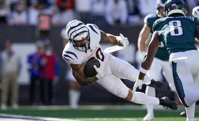 Cincinnati Bengals running back Chase Brown, left, dives in for a touchdown in front of Philadelphia Eagles safety C.J. Gardner-Johnson (8) during the second half of an NFL football game, Sunday, Oct. 27, 2024 in Cincinnati. (AP Photo/Carolyn Kaster)