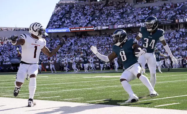 Philadelphia Eagles safety C.J. Gardner-Johnson (8) holds the ball after intercepting a pass intended for Cincinnati Bengals wide receiver Ja'Marr Chase (1) during the second half of an NFL football game, Sunday, Oct. 27, 2024 in Cincinnati. Eagles' Isaiah Rodgers (34) looks on. (AP Photo/Carolyn Kaster)