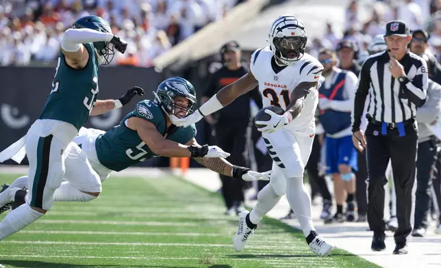 Cincinnati Bengals running back Zack Moss (31) is pushed out of bounds by Philadelphia Eagles linebacker Zack Baun, center, and safety Reed Blankenship, left, during the first half of an NFL football game, Sunday, Oct. 27, 2024 in Cincinnati. (AP Photo/Jeff Dean)