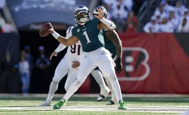 Philadelphia Eagles quarterback Jalen Hurts (1) launches a long touchdown pass to wide receiver DeVonta Smith during the second half of an NFL football game against the Cincinnati Bengals, Sunday, Oct. 27, 2024 in Cincinnati. (AP Photo/Carolyn Kaster)