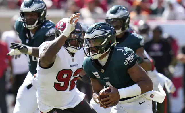 Philadelphia Eagles' Jalen Hurts (1) tries to get past Tampa Bay Buccaneers' William Gholston (92) during the second half of an NFL football game, Sunday, Sept. 29, 2024, in Tampa, Fla. (AP Photo/Chris O'Meara)