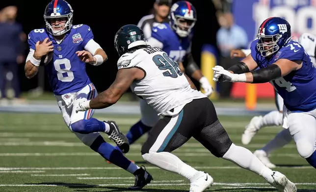 New York Giants quarterback Daniel Jones (8) carries the ball against Philadelphia Eagles defensive tackle Jalen Carter (98) during the first quarter of an NFL football game, Sunday, Oct. 20, 2024, in East Rutherford, N.J. (AP Photo/Frank Franklin II)