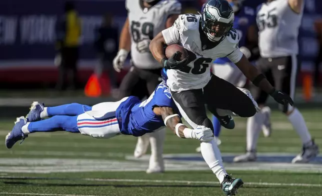 Philadelphia Eagles running back Saquon Barkley (26) avoids a tackle from New York Giants safety Jason Pinnock (27) during the third quarter of an NFL football game, Sunday, Oct. 20, 2024, in East Rutherford, N.J. (AP Photo/Seth Wenig)