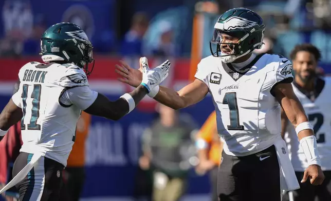 Philadelphia Eagles quarterback Jalen Hurts (1) celebrates with wide receiver A.J. Brown (11) after scoring a touchdown against the New York Giants during the second quarter of an NFL football game, Sunday, Oct. 20, 2024, in East Rutherford, N.J. (AP Photo/Frank Franklin II)