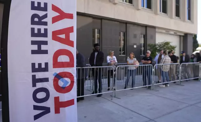 Voters line up outside of the City-County Building for in-person absentee voting, Tuesday, Oct. 8, 2024, in Indianapolis. (AP Photo/Darron Cummings)