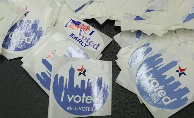 Voting stickers are displayed on a table during in-person absentee voting at the City-County Building, Tuesday, Oct. 8, 2024, in Indianapolis. (AP Photo/Darron Cummings)